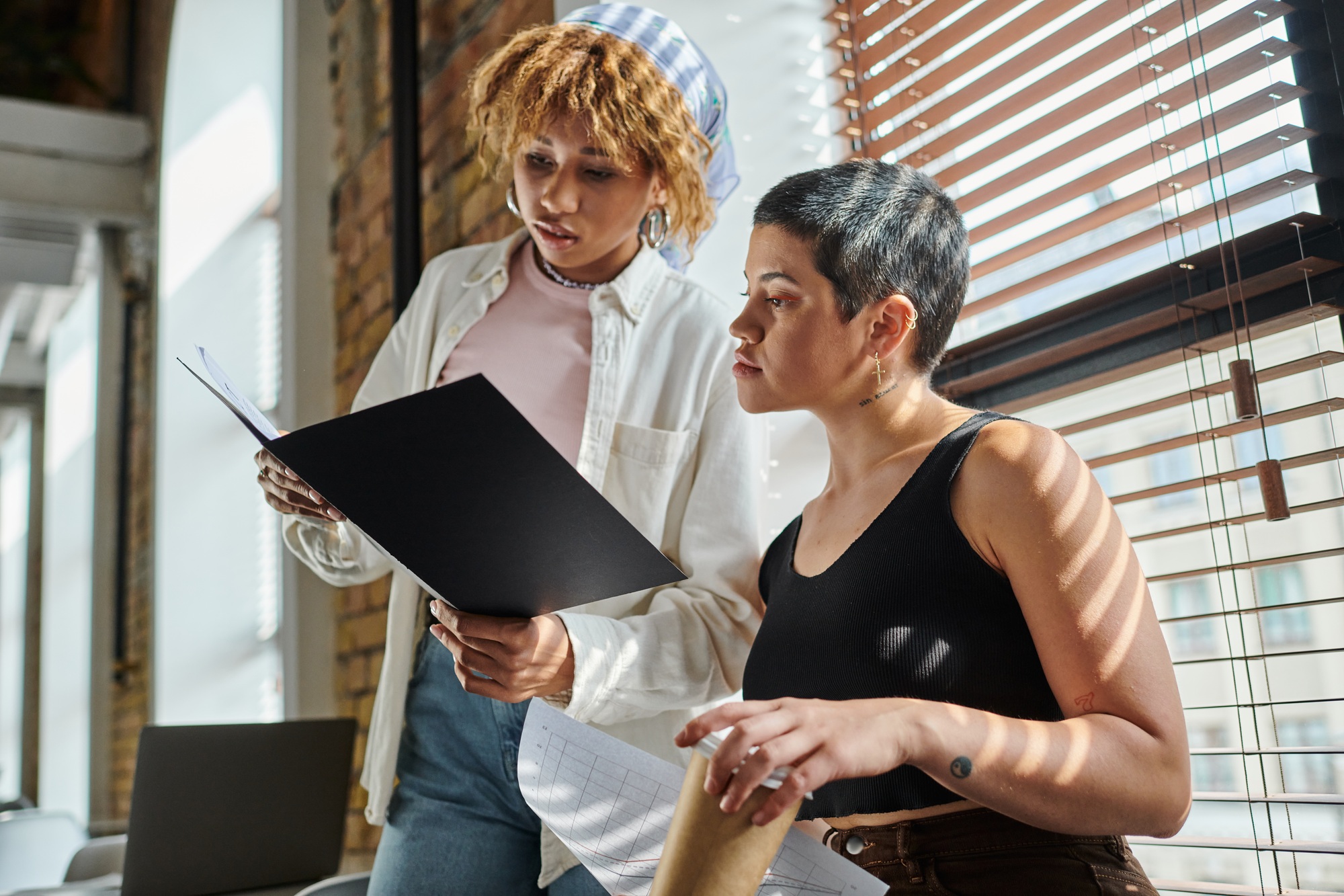 african american woman holding folder with documents, open space, startup project, ideas, colleagues