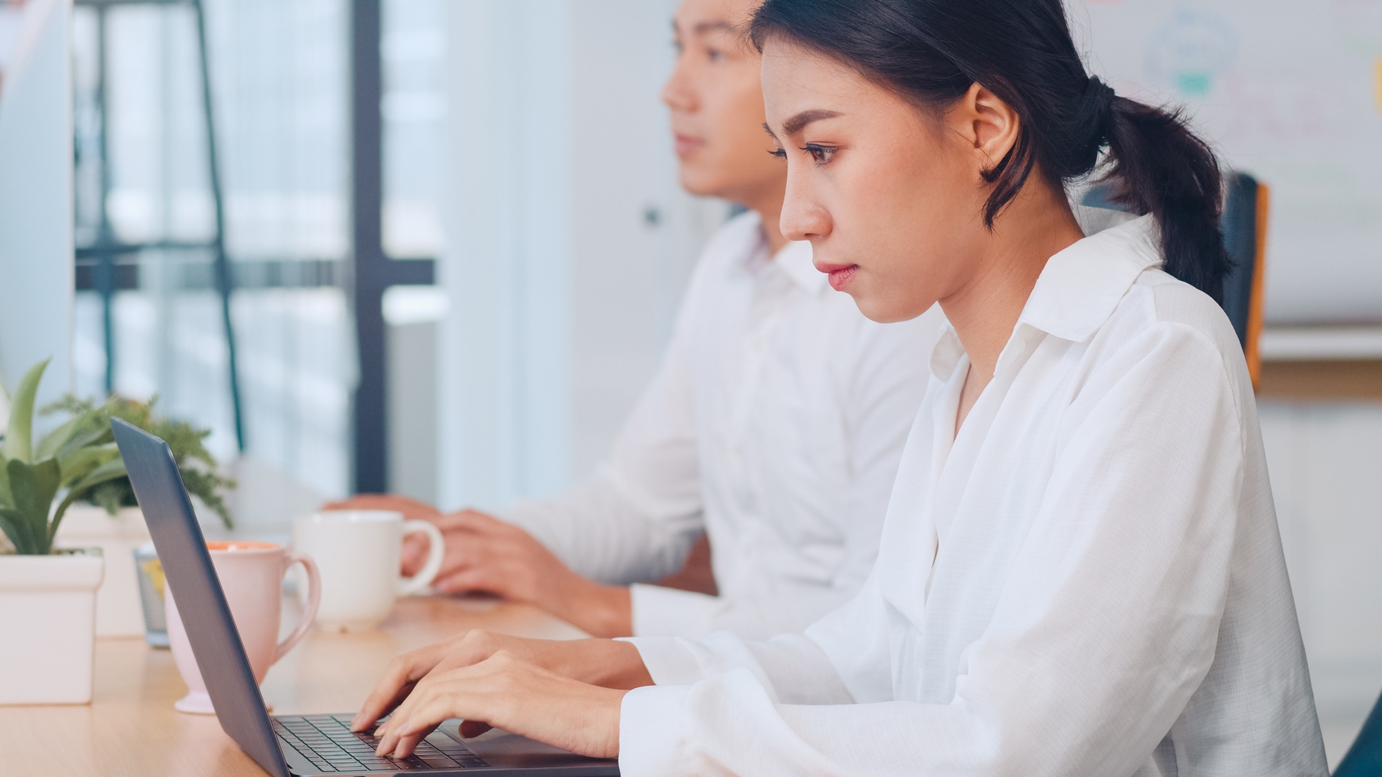 Asia young businesswoman watching tutorial about creative ideas at laptop computer in office.