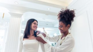 Beautiful bride discussing details with the wedding planner in studio.