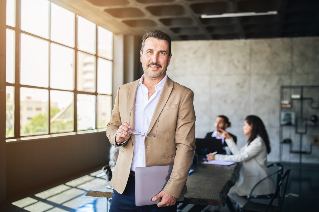Business professional in brown suit holding documents in office meeting