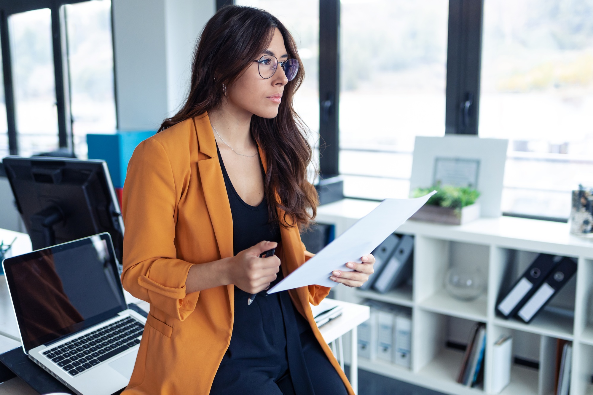 Business young woman thinking and looking to side while working in the office.