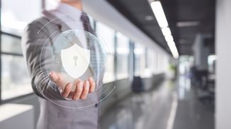 Businessman Presenting Cybersecurity Shield with Digital Interface in Office
