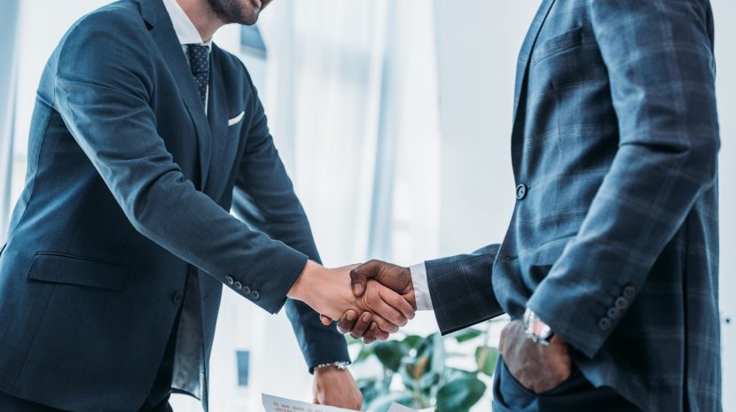 cropped image of smiling multicultural businessmen shaking hands in office