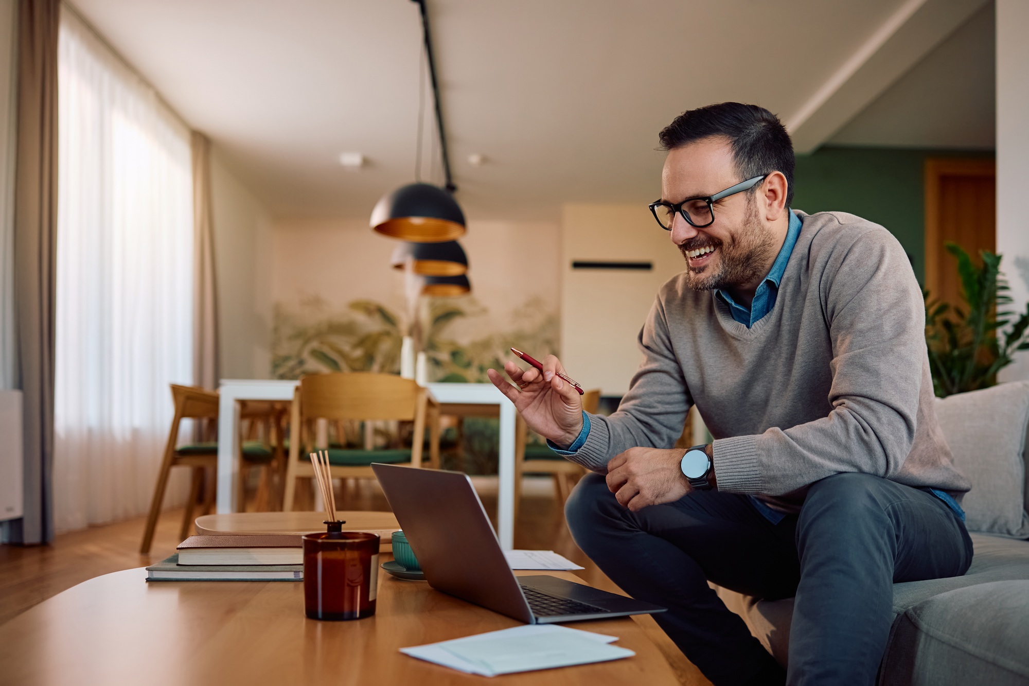 Happy man having online business meeting while working at home.