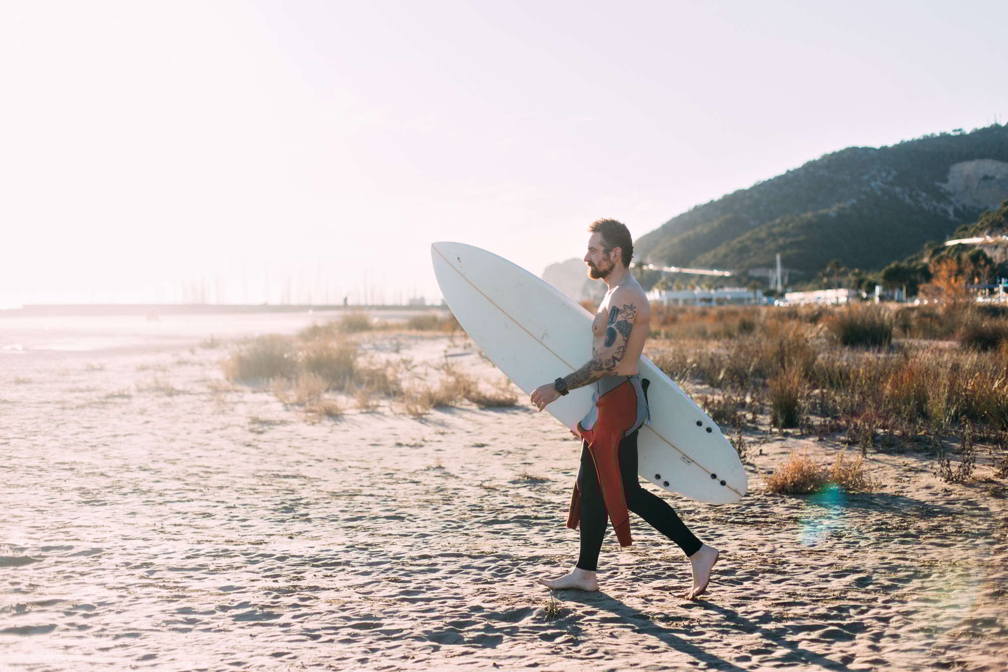 Hipster trendy surfer on beach with surfboard