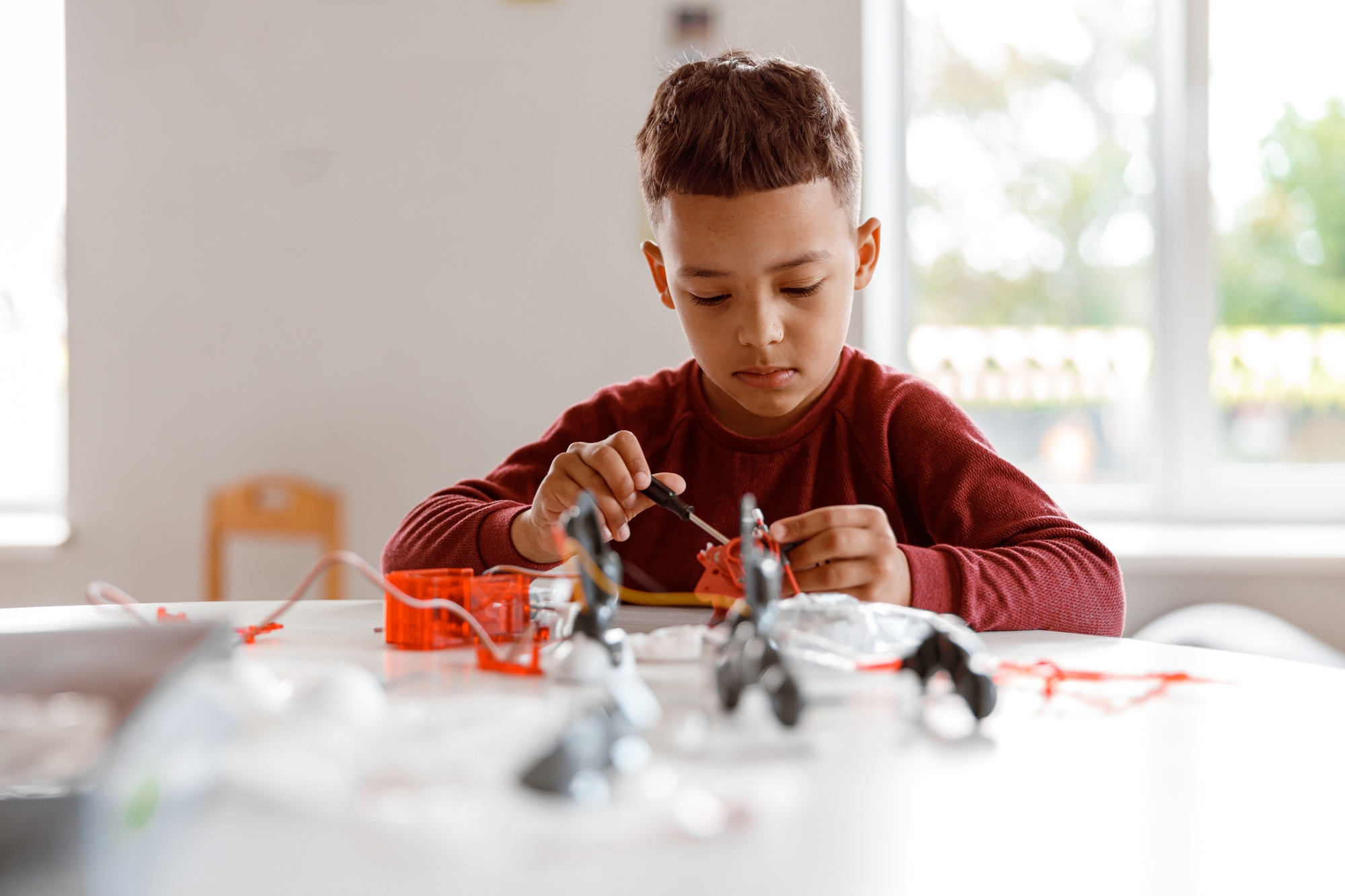 Kid constructing model with constructor details in school