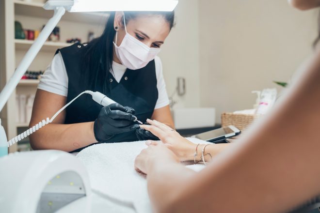 Nail technician giving a manicure to a client in a salon