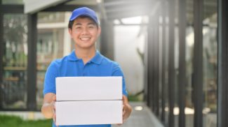 Parcel delivery worker holding a box in hand ready to deliver to customer, Delivery concept.