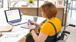 Pretty designer in casualwear choosing color for website design from palette