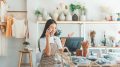 Small business owner talking on the phone with customers in a small shop.