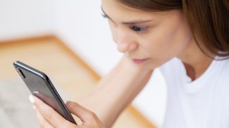 Woman holding smart phone chatting in social media