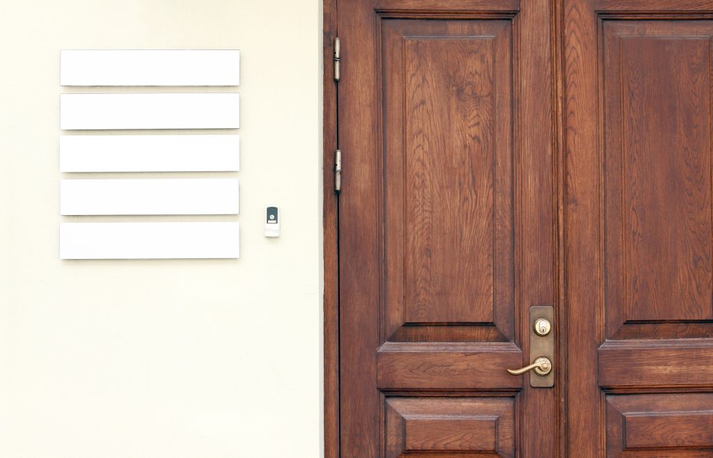 Wooden office doors with blank company signboards on the wall