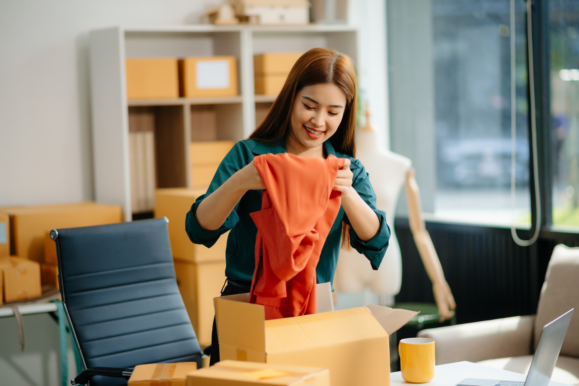 Young Asian women selling clothes on video streaming.Startup small business SME, using smartphone