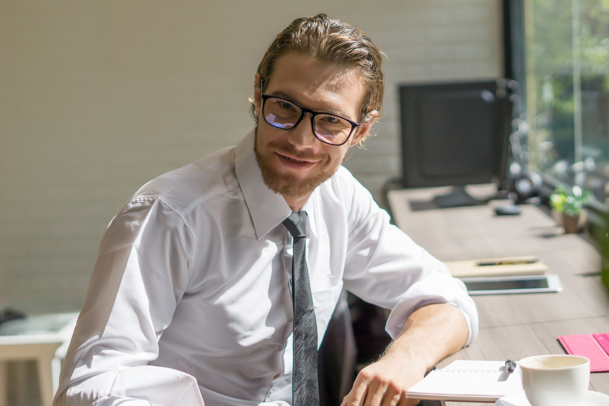 Young hipster businessman working on his workplace with laptop on table. Business working concept.